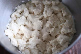 把中种面团撕成小块，加入主面团，放入厨师机盆里，启动一档和面。