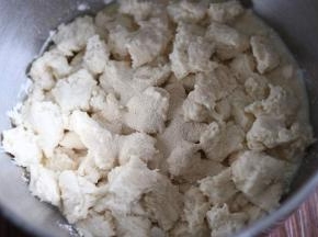 把中种面团撕成小块，加入主面团，放入厨师机盆里，启动一档和面。