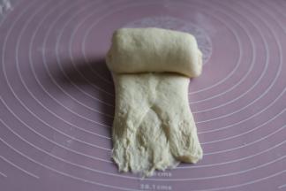 用擀面杖擀开，从上往下卷起。