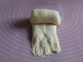用擀面杖擀开，从上往下卷起。