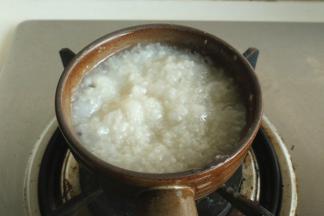 小锅放在煤气灶上，小心放平。先把粥底加热，大约需要三四分钟。