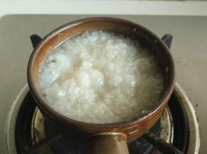 小锅放在煤气灶上，小心放平。先把粥底加热，大约需要三四分钟。