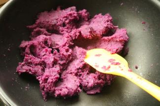 蒸好的去皮紫薯泥加入白糖、牛奶和玉米油，放入不粘锅翻炒。