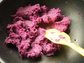 蒸好的去皮紫薯泥加入白糖、牛奶和玉米油，放入不粘锅翻炒。