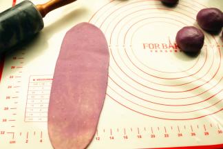 取一个面团，按扁，擀开成牛舌状。