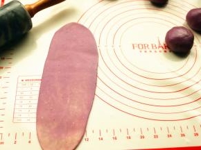 取一个面团，按扁，擀开成牛舌状。