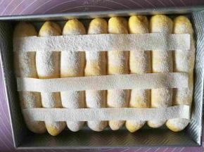 发酵面团两倍大，表面筛粉。我剪了三条油纸，筛粉装饰。
