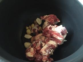把生姜大蒜还有牛排，放入电压锅内胆中；
