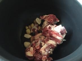 把生姜大蒜还有牛排，放入电压锅内胆中；