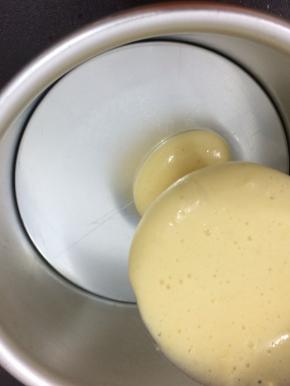 拿个六寸模具，将白色面糊倒入一勺，在倒入可可粉面糊