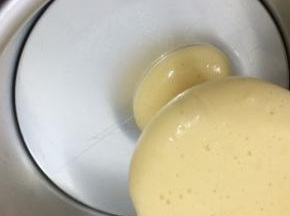 拿个六寸模具，将白色面糊倒入一勺，在倒入可可粉面糊