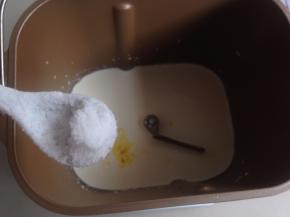 将淡奶油、牛奶、蛋黄放入面包桶，对角加糖和盐