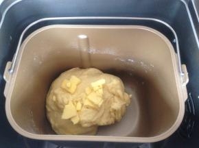 第一次和面10分钟结束后，加入切成小块的黄油，再次选择和面18分钟