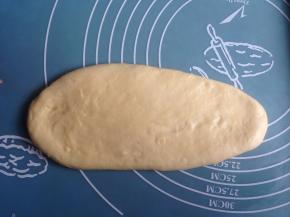 将面团取出排气，擀成椭圆形