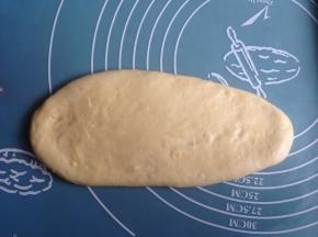 将面团取出排气，擀成椭圆形