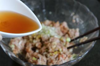 加入适量盐、生抽、黑胡椒粉，分次倒入花椒水，顺时针搅拌搅打上劲；