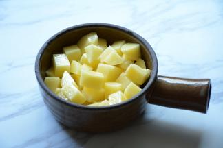 将土豆放入小锅中垫底。