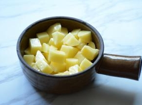将土豆放入小锅中垫底。