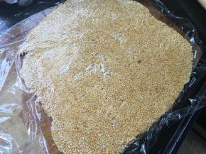 找个菜板或者不沾烤盘什么方便用什么，马上装出来。用保鲜膜盖上趁着热度用擀面杖擀平，擀成薄片。