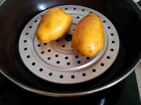 土豆放锅里蒸熟。