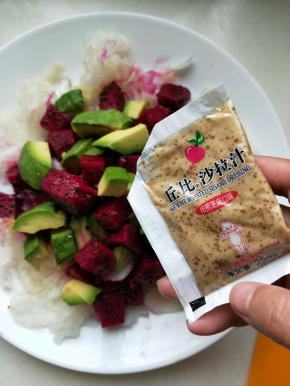 在放上剩下的火龙果和牛油果，准备一袋丘比培煎沙拉汁