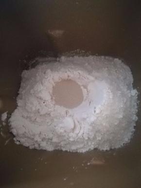 2.除黄油以外，将饼皮材料按下层液体，中层粉体，上层酵母的顺序，放入面包机中揉面。揉成光滑面团后加入软化的黄油，继续揉到扩展阶段就行。