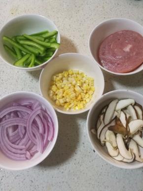 8.青椒和洋葱切丝，香菇切薄片，玉米粒直接切下来就可以了，火腿切小块。