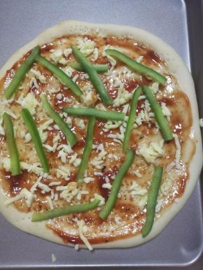 12.涂好酱后撒上一些马苏里拉芝士碎，放上青椒。