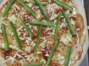 12.涂好酱后撒上一些马苏里拉芝士碎，放上青椒。