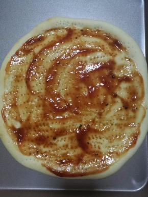 11.烤五分钟之后的披萨饼皮，拿出来上面涂上番茄酱或者披萨酱。