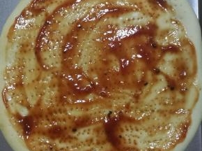 11.烤五分钟之后的披萨饼皮，拿出来上面涂上番茄酱或者披萨酱。