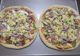 13.再撒上一点点芝士碎，铺上洋葱，火腿，玉米粒等。