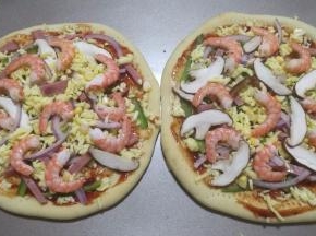14.食材和芝士碎交错这撒在饼皮上，最后摆上剥壳的虾仁。