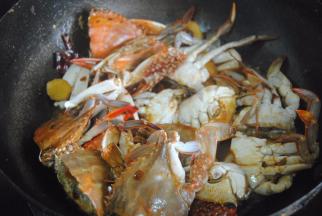 加入料酒，蚝油酱油翻炒均匀至螃蟹变色，倒入半碗清水焖煮3分钟