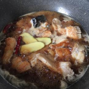 放入辣椒、姜片、生抽、老抽、冰糖、料酒、水大火烧开，转中火十分钟