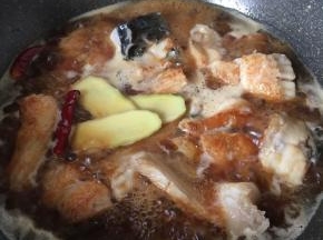 放入辣椒、姜片、生抽、老抽、冰糖、料酒、水大火烧开，转中火十分钟
