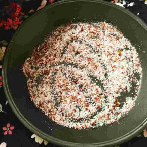 披萨盘里放入另一半玫瑰花粉和椰蓉搅拌均匀