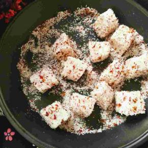 将牛奶小方放在玫瑰椰蓉粉里滚一圈