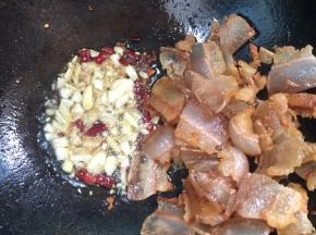 把多余的油倒出来，留少许底油，放入花椒，干辣椒，蒜瓣，生姜，炒香！




