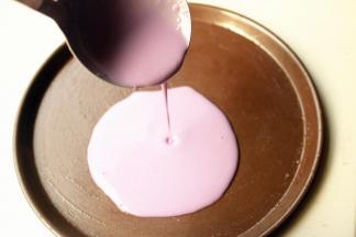 选择不沾的披萨盘，刷一点点油，舀一勺面糊，从中间注入盘子，晃动盘子使面糊铺满盘子。