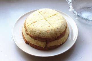 找一个大点的盘子，把蛋糕胚子倒扣在盘子中