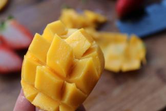 芒果对半剖开，去核，斜切花刀。