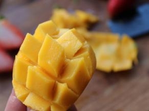 芒果对半剖开，去核，斜切花刀。