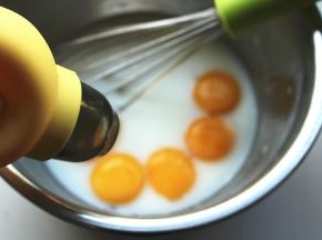 用分蛋器分离蛋黄和蛋白，蛋黄加入牛奶玉米油混合物。