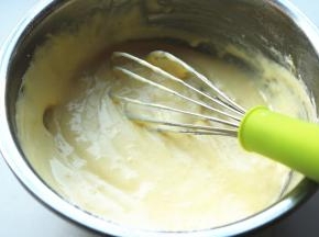 挖一些蛋白霜到蛋黄糊里，之字形搅拌均匀。