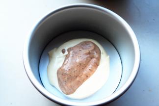 蛋糕模先挖一勺白色蛋糕糊在底部中间，再挖一勺巧克力面糊在白色面糊上面。