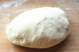 发酵好的面团移到面板上，撒多一些干粉，揉成光滑的面团。