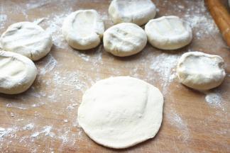 按扁，擀成边缘薄中间厚的面皮。