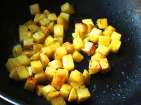 炒锅放油，下入土豆块煎至表面金黄。