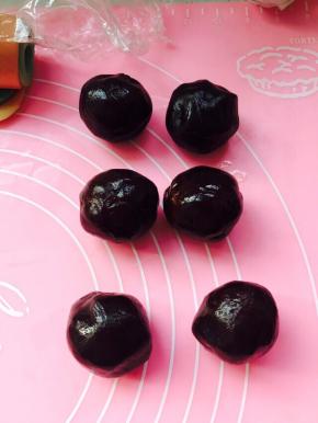 静止过程中，用豆沙把蛋黄包裹好，豆沙的量取决于蛋黄的大小，它们在一起大概35克左右就可以